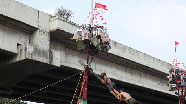 Peserta mengikuti lomba memanjat pohon pinang di Semarak Kalimalang 2026 di Jakarta, Senin (17/8/2026). [Suara.com/Novi]

