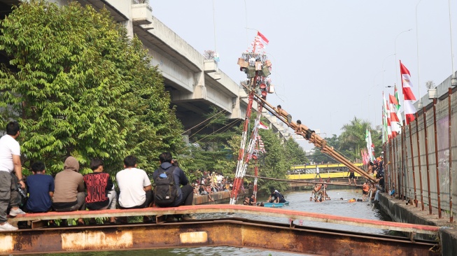 Peserta mengikuti lomba memanjat pohon pinang di Semarak Kalimalang 2026 di Jakarta, Senin (17/8/2026). [Suara.com/Novi]
