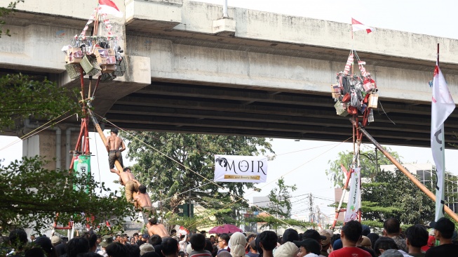Peserta mengikuti lomba memanjat pohon pinang di Semarak Kalimalang 2026 di Jakarta, Senin (17/8/2026). [Suara.com/Novi]
