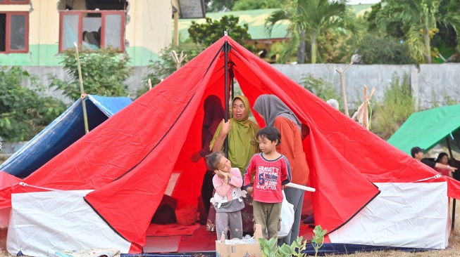 Warga beristirahat di tenda posko pengungsian korban gempa bumi NTT di Lapangan Barangkolong, Reo, NTT, Senin (17/8/2026). [ANTARA FOTO/Fikri Yusuf/foc]