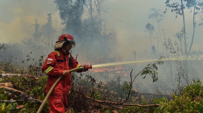 Petugas Manggala Agni Daops Muara Bulian memadamkan api yang membakar lahan di Tenam, Batang Hari, Jambi, Jumat (21/8/2026). [ANTARA FOTO/Wahdi Septiawan/YU]