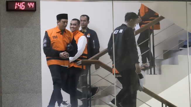 Wakil Rektor Bidang Kemahasiswaan Universitas Jenderal Soedirman (Unsoed) Norman Arie Prayogo bersama tersangka lainnya berjalan menuju mobil tahanan usai menjalani pemeriksaan pasca terjaring operasi tangkap tangan (OTT) di Gedung KPK, Jakarta, Sabtu (22/8/2026) dini hari. [Suara.com/Alfian Winanto]
