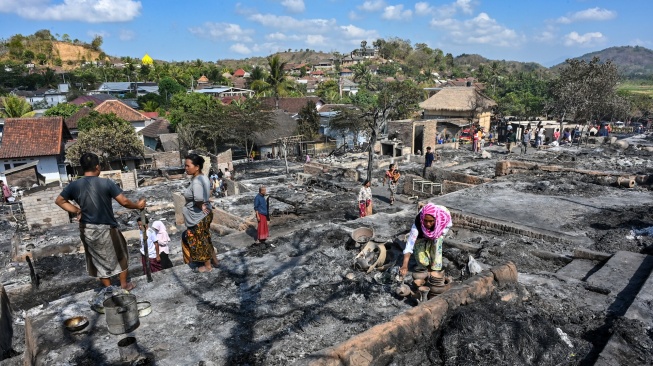 Warga mengais puing sisa barang-barang mereka yang terbakar di Desa Adat Sade, Rembitan, Kecamatan Pujut, Praya, Lombok Tengah, NTB, Minggu (23/8/2026). [ANTARA FOTO/Ahmad Subaidi/wsj]