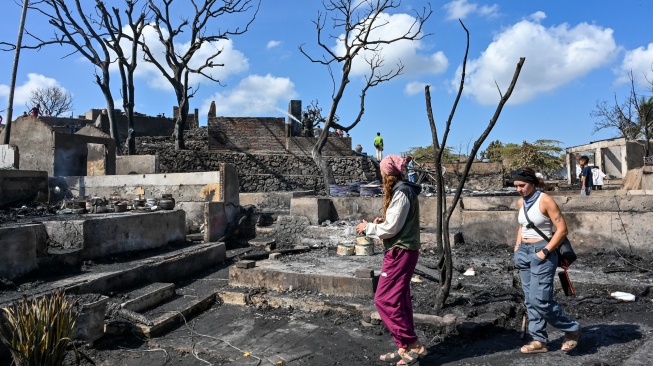 Sejumlah wisatawan asing melihat suasana pascakebakaran di Desa Adat Sade, Rembitan, Kecamatan Pujut, Praya, Lombok Tengah, NTB, Minggu (23/8/2026). [ANTARA FOTO/Ahmad Subaidi/wsj]