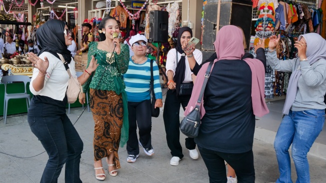 Warga dan para pengunjung pasar menyanyi bersama saat program GEMPAR di Pasar Godean, Sleman, Yogyakarta, Senin (24/8/2026). [Suara.com]
