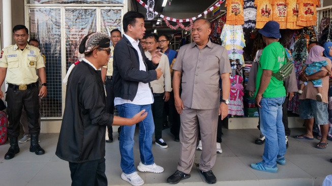 Pemimpin Redaksi Suara.com Suwarajono berbincang dengan Bupati Sleman Harda Kiswaya saat pembukaan program GEMPAR di Pasar Godean, Sleman, Yogyakarta, Senin (24/8/2026). [Suara.com]