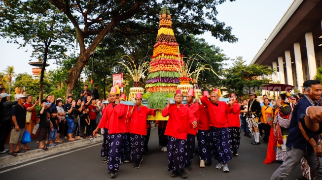 Pasukan Lombok Abang dan sejumlah warga mengarak gunungan berisi sayur-sayuran saat prosesi Grebeg Maulud di Taman Mini Indonesia Indah, Jakarta, Selasa (25/8/2026).  [Suara.com/Alfian Winanto]