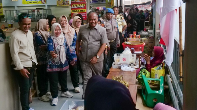Bupati Sleman Harda Kiswaya menyapa para pedagang di tengah program GEMPAR di Pasar Godean, Sleman, Yogyakarta, Senin (24/8/2026). [Suara.com]
