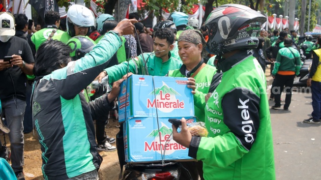 Pengemudi ojek online (ojol) membantu memindahkan logistik di depan Gedung DPR RI, Jakarta, Rabu (26/8/2026). [Suara.com/Alfian Winanto]
