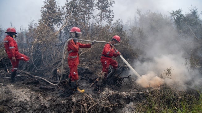 Foto udara Petugas dari Manggala Agni Daops Sumatera IX-Kota Jambi melakukan pemadaman kebakaran lahan gambut di Desa Kota Bumi, Kecamatan Tanjung Lubuk, Kabupaten Ogan Komering Ilir (OKI), Sumatera Selatan, Rabu (26/8/2026). [ANTARA FOTO/Nova Wahyudi/nym]