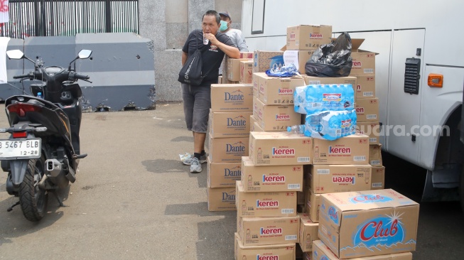 Pengemudi ojek online (ojol) membantu memindahkan logistik di depan Gedung DPR RI, Jakarta, Rabu (26/8/2026). [Suara.com/Alfian Winanto]
