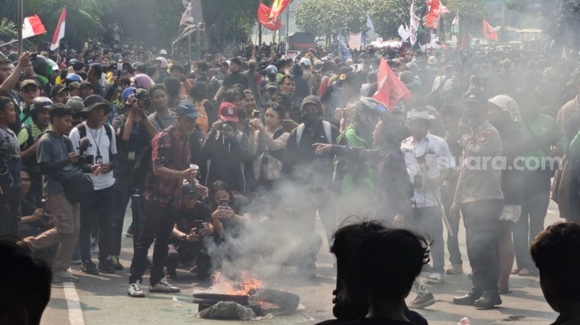 Sejumlah massa mahasiswa membakar ban saat hendak aksi di depan Gedung DPR RI, Senayan, Jakarta, Kamis (27/8/2026). (Suara.com/Adiyoga)