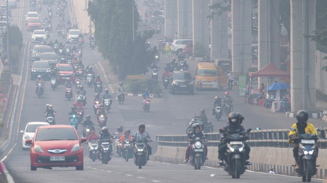 Sejumlah pengendara melintas di atas jembatan layang simpang Jakabaring yang tertutup kabut asap di Palembang, Sumatera Selatan, Kamis (27/6/2026). [ANTARA FOTO/Nova Wahyudi/foc]