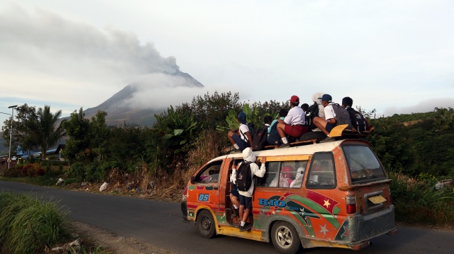 Siswa berangkat sekolah menaiki angkutan umum saat erupsi Gunung Sinabung di Desa Kutarayat, Kecamatan Naman Teran, Kabupaten Karo, Sumatera Utara, Selasa (1/9/2026). [ANTARA FOTO/Yudi Manar/YU]