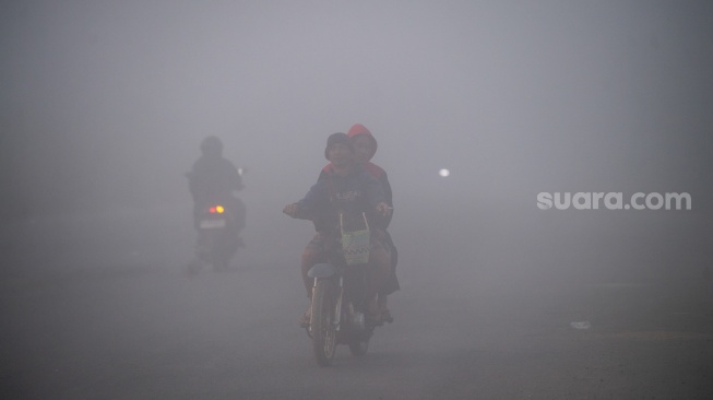 Pengendara melintas di jalan lingkar selatan Palembang-Banyuasin yang tertutup kabut asap di Kabupaten Banyuasin, Sumatera Selatan, Rabu (2/9/2026). [ANTARA FOTO/Nova Wahyudi/nz]