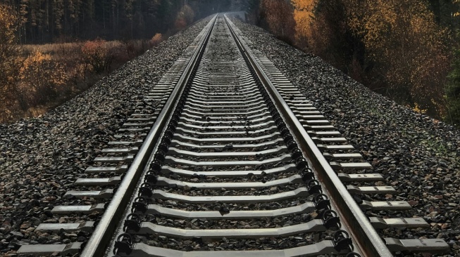 Rel kereta api, atau perlintasan kereta api. [Unsplash/Jake Weirick]