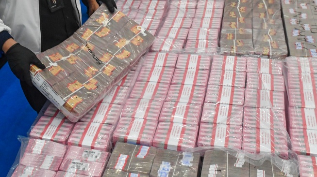 Petugas Direktorat Tindak Pidana Siber (Dittipidsiber) Polri menata barang bukti berupa pecahan uang 100 ribu rupiah saat pengungkapan kasus kejahatan siber di Gedung Awaloedin Djamin Bareskrim Polri, Jakarta, Kamis (3/9/2026). [ANTARA FOTO/Muhammad Adimaja/agr]
