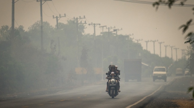 Pengendara sepeda motor melintas di Jalan Gubernur Syarkawi yang tertutup kabut asap akibat kebakaran hutan dan lahan (karhutla) di Kabupaten Banjar, Kalimantan Selatan, Rabu (2/9/2026). [ANTARA FOTO/Bayu Pratama S/nym]