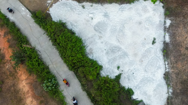 Foto udara pengendara motor melintas di dekat lokasi yang diduga tercemar limbah Bahan Berbahaya dan Beracun (B3) Potasium-40 di Kampung Bayur, Desa Nambo Udik, Kabupaten Serang, Banten, Kamis (3/9/2026). [ANTARA FOTO/Muhammad Bagus Khoirunas/wsj]
