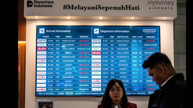 Petugas berada di dekat layar informasi jadwal kedatangan dan keberangkatan pesawat di Bandara Internasional Jenderal Ahmad Yani, Semarang, Jawa Tengah, Senin (7/9/2026). [ANTARA FOTO/Aprillio Akbar/tom]