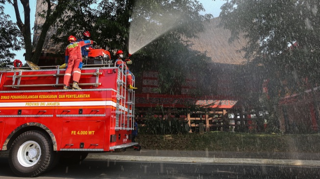 Petugas Dinas Penanggulangan Kebakaran dan Penyelamatan (Gulkarmat) melakukan penyemprotan air di kawasan Taman Mini Indonesia Indah (TMII), Jakarta, Senin (7/9/2026). [ANTARA FOTO/Angga Budhiyanto/agr]