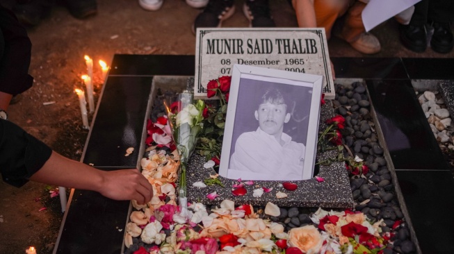 Seorang mahasiswa menabur bunga dalam aksi simbolik mengenang 22 tahun kematian Munir Said Thalib di TPU Sisir, Kota Batu, Jawa Timur, Senin (7/9/2026). [ANTARA FOTO/Irfan Sumanjaya/nym]