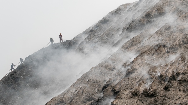 Petugas Pemadam Kebakaran (Damkar) dibantu anggota TNI berusaha memadamkan titik api kebakaran gunungan sampah di TPA Putri Cempo Solo, Jawa Tengah, Selasa (8/9/2026). [ANTARA FOTO/Mohammad Ayudha/nz]