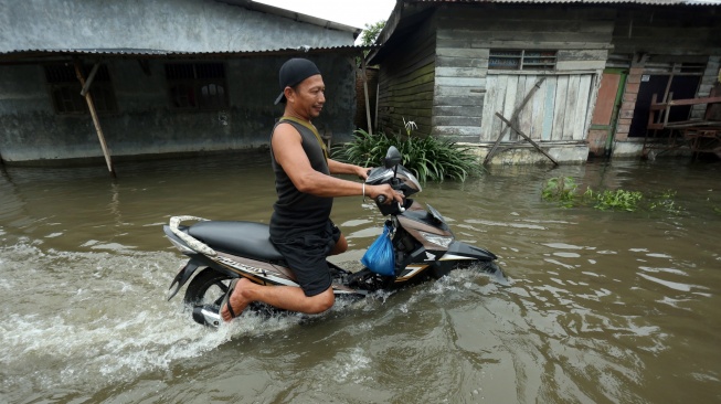 Pengendara motor menerobos banjir di Martubung, Kecamatan Medan Labuhan, Kota Medan, Sumatera Utara, Kamis (10/9/2026). [ANTARA FOTO/Yudi Manar/wsj]