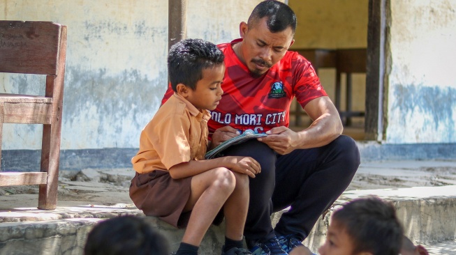 Guru menyampaikan pelajaran kepada siswa di bawah pohon karena gedung kelas mereka rusak di SDN Jarak, Desa Golo Mori, Kecamatan Komodo, Manggarai Barat, NTT, Rabu (9/9/2026). [ANTARA FOTO/Gecio Viana/app/nym]