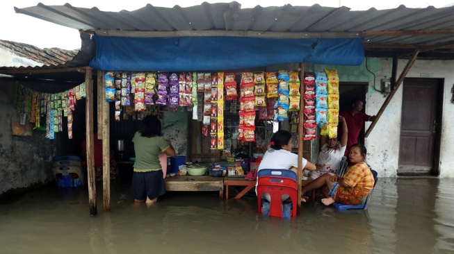 Pedagang tetap berjualan saat banjir merendam kawasan Martubung di Kecamatan Medan Labuhan, Kota Medan, Sumatera Utara, Kamis (10/9/2026). [ANTARA FOTO/Yudi Manar/wsj]