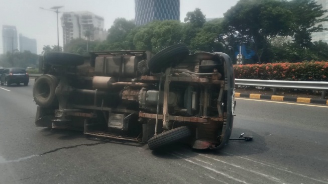 Sebuah Truk Terguling di Jalan Tol Dalam Kota Akibat Pecah Ban, Kernet Alami Luka-luka