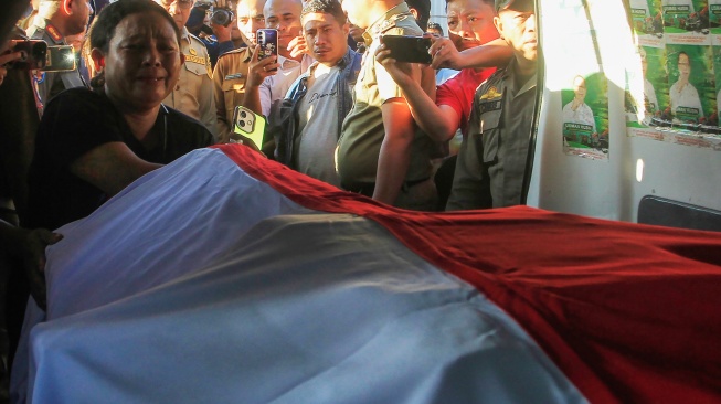 Salah satu kerabat menangis di depan peti berisi jenazah Wili Mbuik yang tiba di Bandara El Tari Kupang, Provinsi NTT, Jumat (11/9/2026). [ANTARA FOTO/Kornelis Kaha/app/YU]