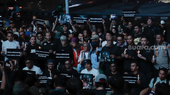 Sejumlah anggota Pewarta Foto Indonesia (PFI) dan jurnalis menggelar doa bersama di Bundaran HI, Jakarta, Jumat (11/9/2026). [Suara.com/Alfian Winanto]
