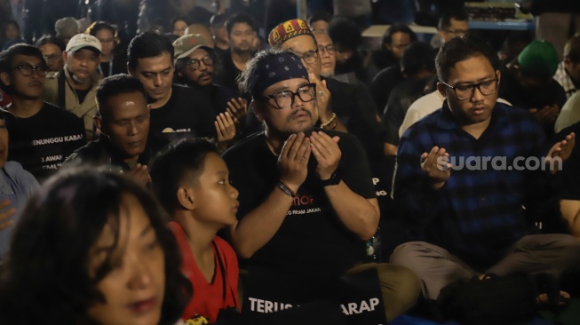 Sejumlah anggota Pewarta Foto Indonesia (PFI) dan jurnalis menggelar doa bersama di Bundaran HI, Jakarta, Jumat (11/9/2026). [Suara.com/Alfian Winanto]
