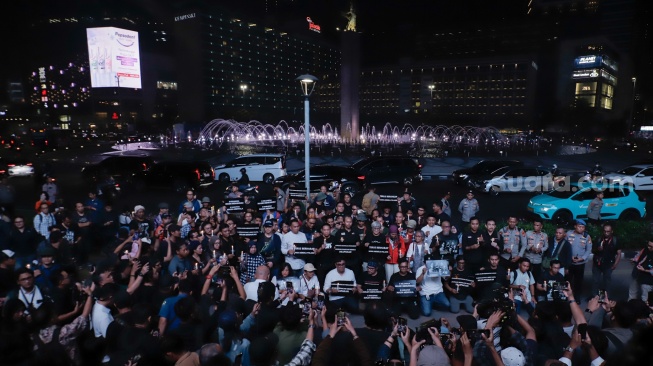 Sejumlah anggota Pewarta Foto Indonesia (PFI) dan jurnalis menggelar doa bersama di Bundaran HI, Jakarta, Jumat (11/9/2026). [Suara.com/Alfian Winanto]