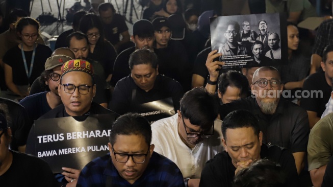 Sejumlah anggota Pewarta Foto Indonesia (PFI) dan jurnalis menggelar doa bersama di Bundaran HI, Jakarta, Jumat (11/9/2026). [Suara.com/Alfian Winanto]