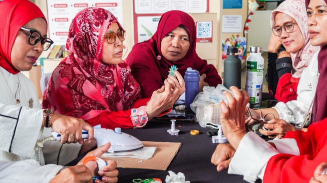 Salah satu workshop TelkomGroup adalah pengolahan kemasan plastik menjadi produk fesyen bersama Bank Sampah Sawo Kencana. (Dok: Telkom)