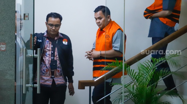 Kepala BPN Kabupaten Bogor Sontang Coin Manurung (tengah) berjalan menuju mobil tahanan usai menjalani pemeriksaan di Gedung Merah Putih KPK, Jakarta, Selasa (15/9/2026). [Suara.com/Alfian Winanto]