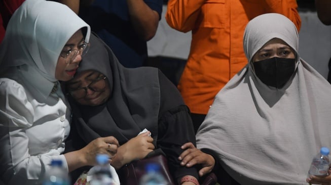 Istri jurnalis ANTARA yang hilang kontak, M Bagus Khoirunas, Desi Purnama Sari (tengah), menangis dalam pelukan kerabatnya didampingi istri jurnalis Merdeka.com, Arie Basuki, Yanti (kanan), usai pertemuan dengan tim SAR gabungan di Carita, Pandeglang, Banten, Kamis (17/9/2026). [ANTARA FOTO/Akbar Nugroho Gumay/kye]