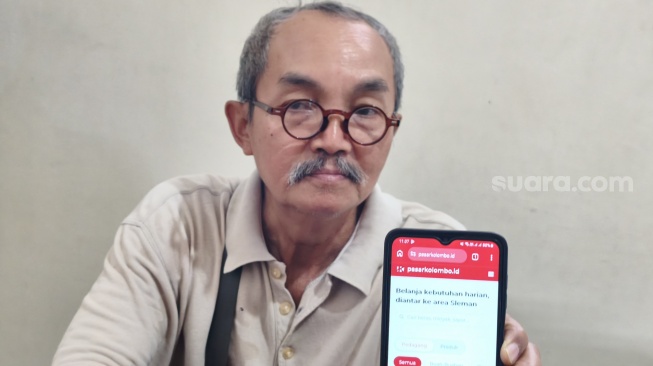 Wakil Lurah Pasar Kolombo, Guntoro, menunjukkan laman pasarkolombo.id.[Suara.com/Hiskia]