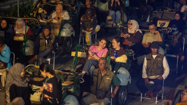 Pengunjung duduk di bangku becak listrik saat acara Becak Drive-in Cinema dalam rangkaian Kotabaru Heritage Festival (KHFF) 2026 di Pasar Terban, Yogyakarta, Kamis (17/9/2026). [ANTARA FOTO/Andreas Fitri Atmoko/kye]