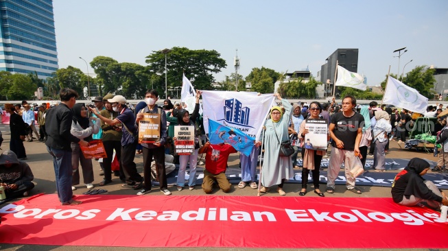 Massa aksi dari Wahana Lingkungan Hidup Indonesia (WALHI) berjoget saat melakukan unjuk rasa dalam rangka Hari Keadilan Ekologis 2026 di depan Gedung DPR RI, Jakarta, Senin (21/9/2026). [Suara.com/Alfian Winanto]
