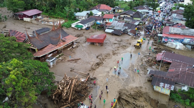 Foto udara alat berat membersihkan jalan akibat dampak banjir bandang menerjang kawasan Arosuka, Kabupaten Solok, Sumatera Barat, Selasa (22/9/2026). [ANTARA FOTO/Fitra Yogi/bar]