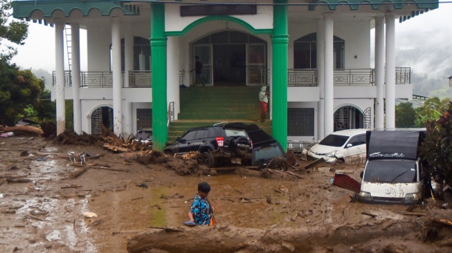 Warga mengecek kondisi kendaraan yang terendam material banjir bandang di Arosuka, Kabupaten Solok, Sumatera Barat, Selasa (22/9/2026). [ANTARA FOTO/Fitra Yogi/bar]