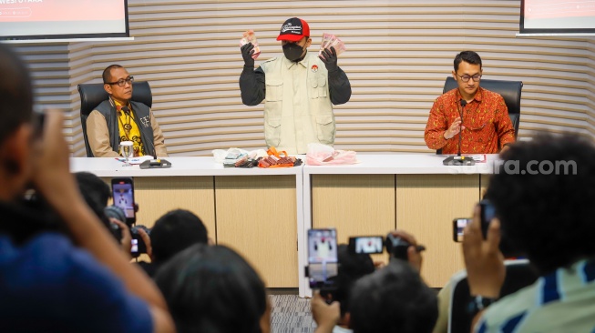 Petugas menunjukan barang bukti berupa uang tunai dari hasil Operasi Tangkap Tangan (OTT) yang melibatkan Bupati Bolaang Mongondow Utara Sirajudin Lasena saat konferensi pers di Gedung Merah Putih KPK, Jakarta, Selasa (22/9/2026). [Suara.com/Alfian Winanto]