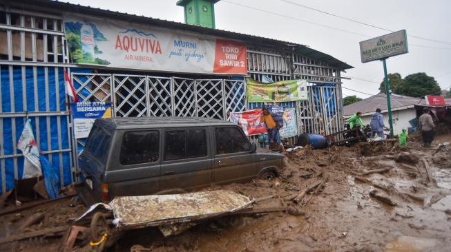 Warga mengecek kondisi kendaraan yang terendam material banjir bandang di Arosuka, Kabupaten Solok, Sumatera Barat, Selasa (22/9/2026). [ANTARA FOTO/Fitra Yogi/bar]