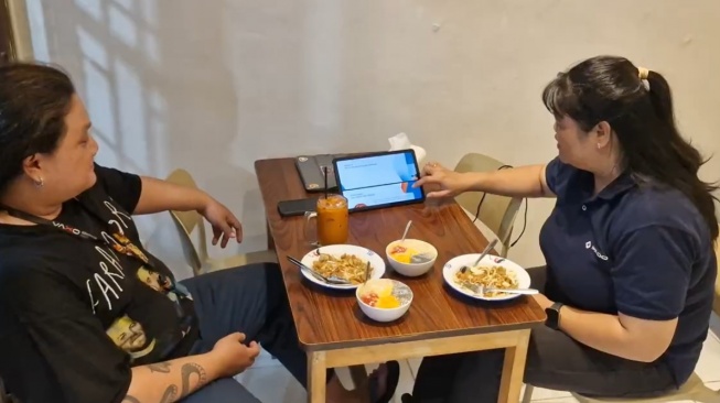 Pelatihan bisnis digital bagi warga Simo Gunung, Surabaya, tak berhenti setelah materi selesai disampaikan. Dosen Institut Informatika Indonesia (IKADO) Surabaya melanjutkan pendampingan kepada pelaku UMKM agar keterampilan yang diperoleh bisa diterapkan dalam usaha sehari-hari. [Suara.com/dok]