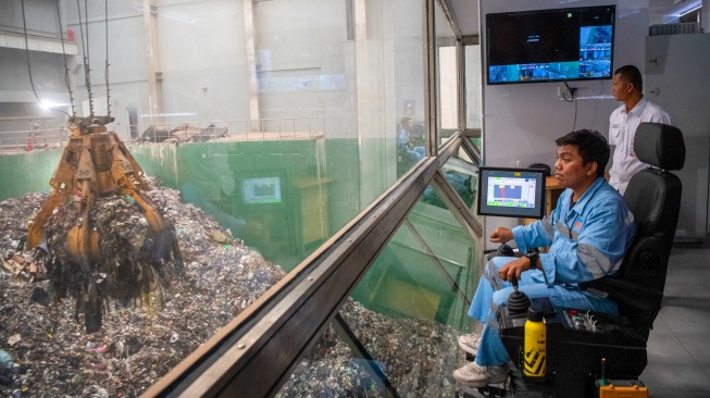 Operator mengoperasikan crane untuk mengangkut sampah menuju tungku pembakaran di tempat Pengolahan Sampah Menjadi Energi Listrik (PSEL) Keramasan, Kertapati, Palembang, Sumatera Selatan, Kamis (24/9/2026). [ANTARA FOTO/Nova Wahyudi/sgd]
