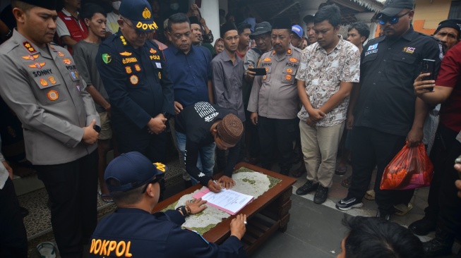 Kepala Bidang Kedokteran dan Kesehatan (Kabid Dokkes) Polda Banten Kombes Pol I Gusti Gede Dharma Arimbawa (kedua kiri) dan Kapolres Pandeglang AKBP Sonny Harsono (kiri) menyaksikan putra anak buah kapal (ABK) Arupadhatu 1, Surakman, Yayat (ketiga kiri), menandatangani berita acara serah terima jenazah di Kampung Pagedongan, Carita, Kabupaten Pandeglang, Banten, Kamis (24/9/2026). [ANTARA FOTO/Rikardo/pma/kye]
