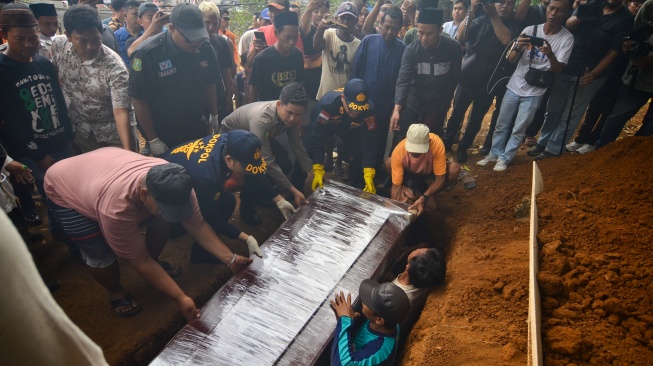 Polisi bersama kerabat memasukkan peti jenazah anak buah kapal (ABK) Arupadhatu 1, Surakman, ke dalam liang lahat di Tempat Pemakaman Umum (TPU) Ki Demang, Kampung Pagedongan, Carita, Kabupaten Pandeglang, Banten, Kamis (24/9/2026). [ANTARA FOTO/Rikardo/pma/kye]
